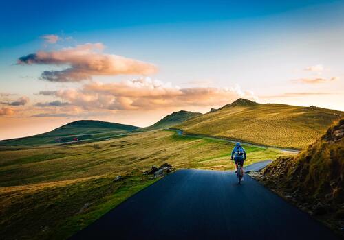 a cyclist on a tarmac road in the countryside