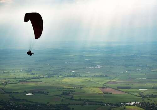 a paraglider over a countryside view