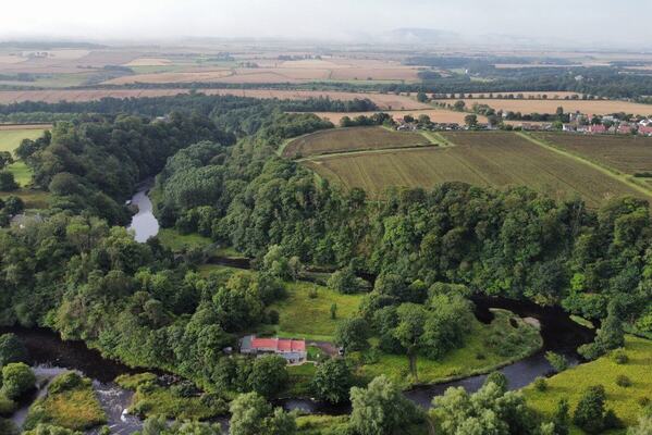 a birds eye view photo of the cottage and surrounding countryside