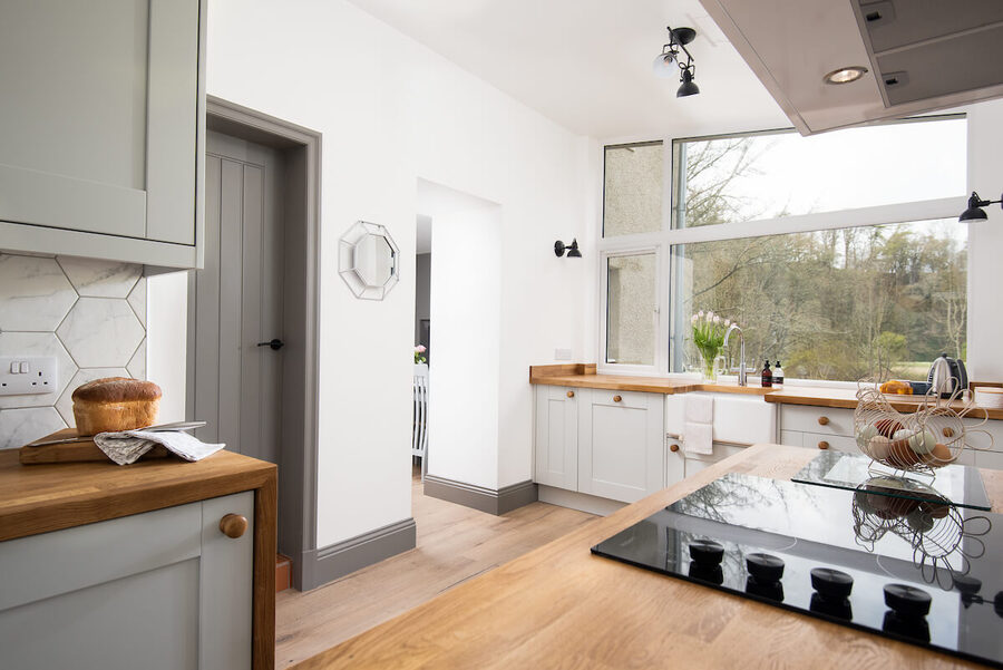 a kitchen with large windows and lots of natural light